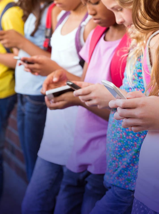 Cute pupils using mobile phone at the elementary school