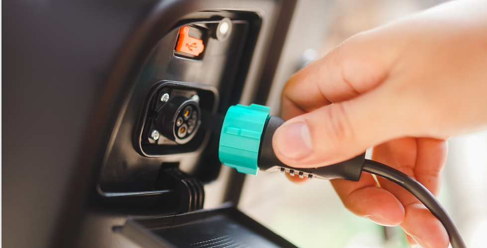 close up view of asian man hand taking off electric bicycle charger