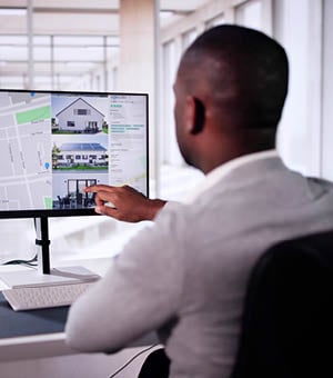 African Man Using Laptop To Search Online Real Estate Property Listings, Marking Possibilities On Screen In Black Rental Market.