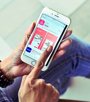 BANGKOK,THAILAND SEPTEMBER 2,2017 : Woman Using Airbnb Apps to Discover entire homes and private rooms perfect for any trip.Influencer millennial Using Social Media on Smartphone, Like, Follower.