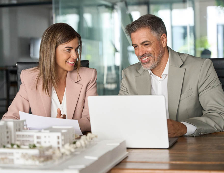 Real estate developers working on laptop discussing new residential or commercial development construction project at meeting. Investing in realty, bank mortgage loan concept.