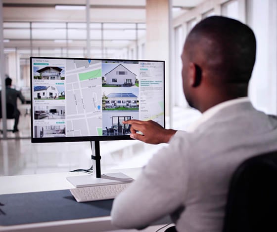 African Man Using Laptop To Search Online Real Estate Property Listings, Marking Possibilities On Screen In Black Rental Market.